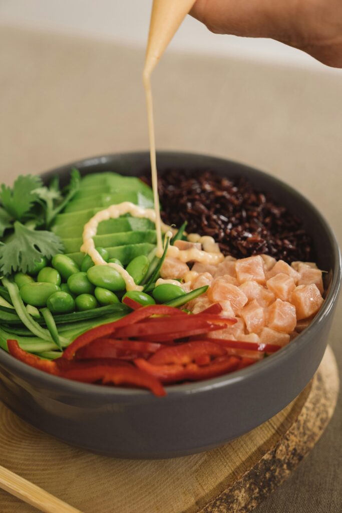 A vibrant Buddha bowl with fresh vegetables and dressing, perfect for healthy eating.