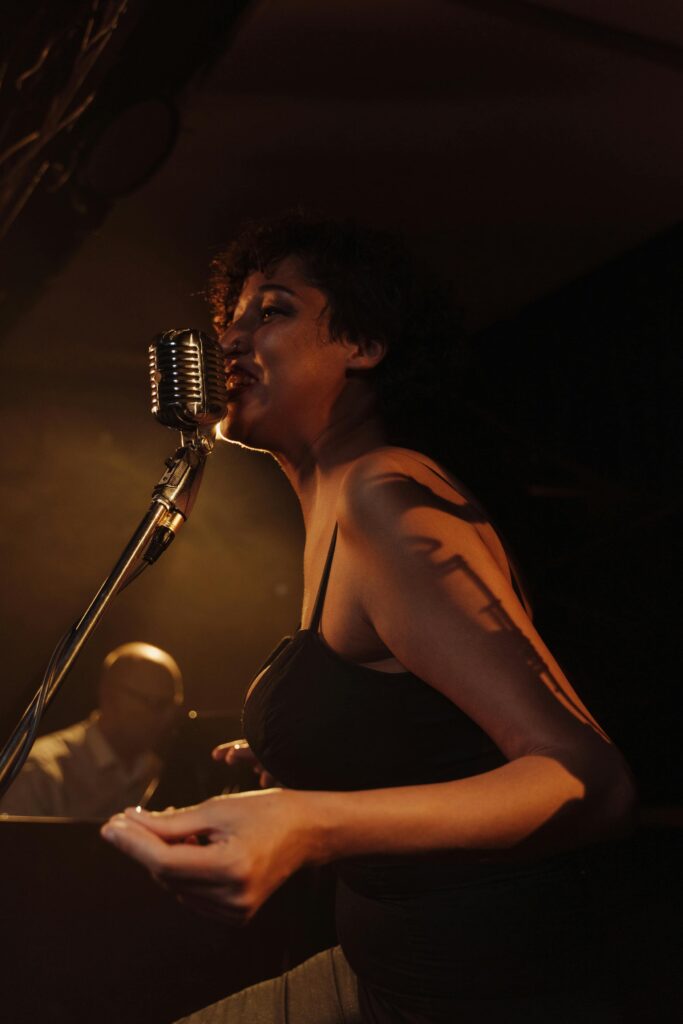 A talented female jazz singer passionately performing with a vintage microphone under warm stage lights.